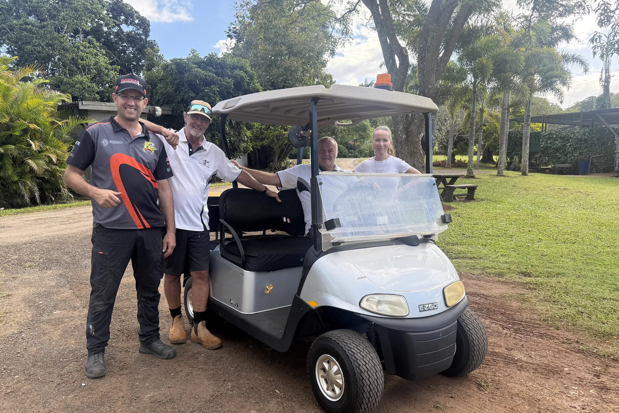 Townlec staff with customers beside a second-hand silver EZGO utility golf cart delivered to Tolga Caravan Park on the Atherton Tablelands
