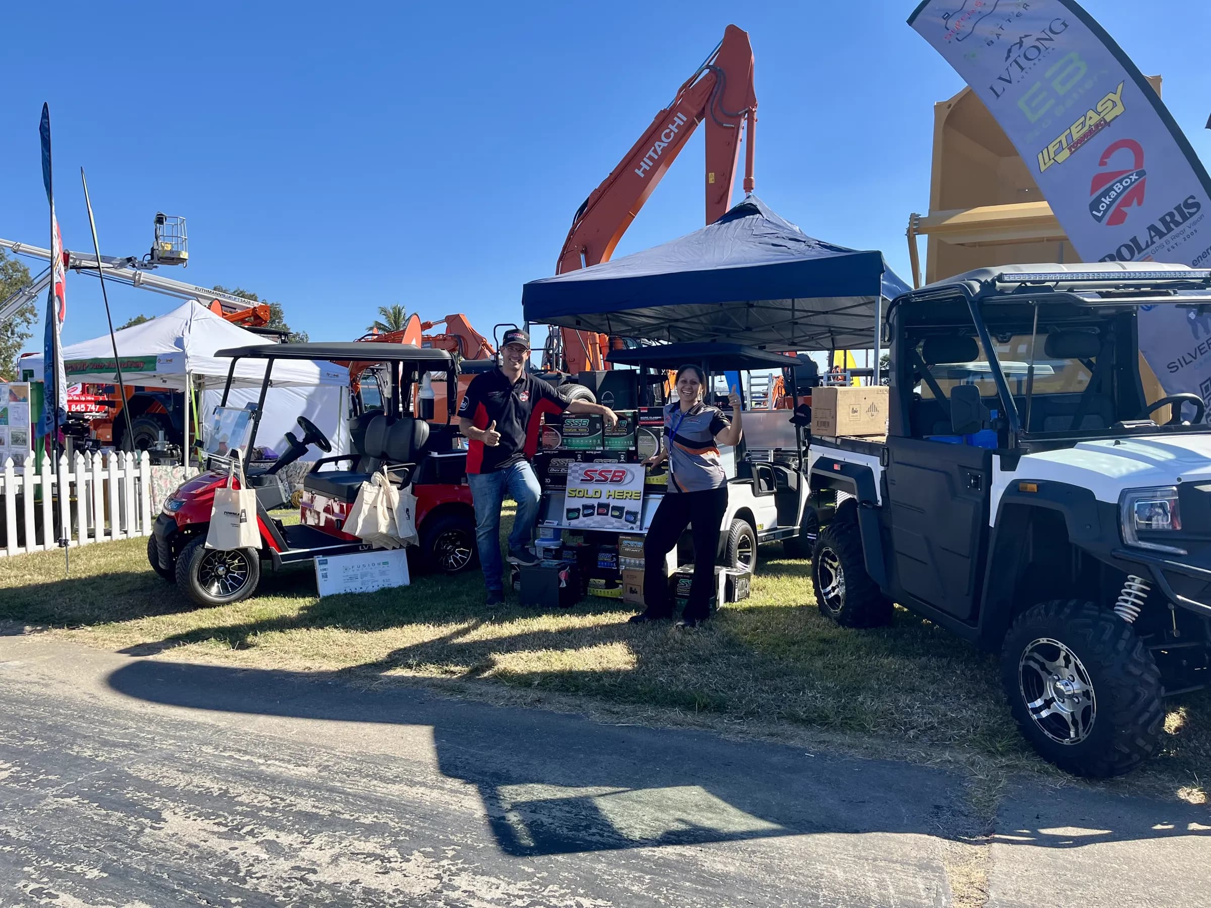 The Townlec trade stand at a North Queensland field day with a red LVTong cart, a white utility cart and an electric UTV on display