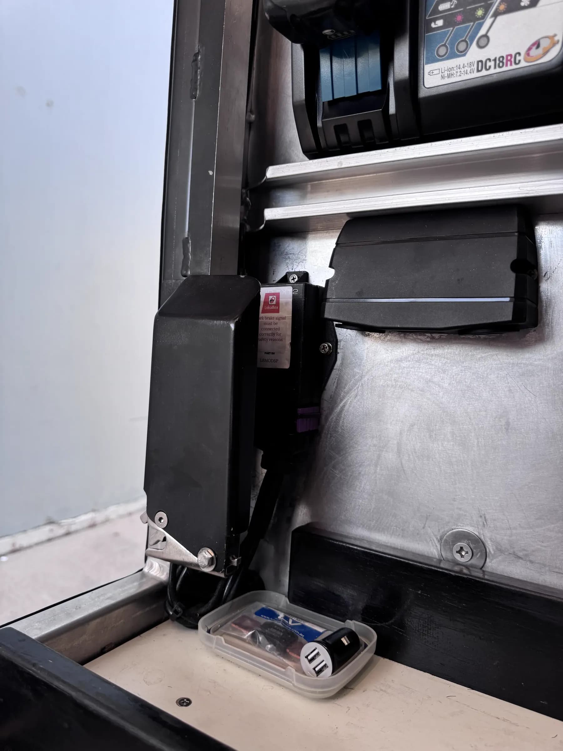 LokaBox control module part number LBMOD5P mounted inside a toolbox, carrying a label about connecting the park brake signal