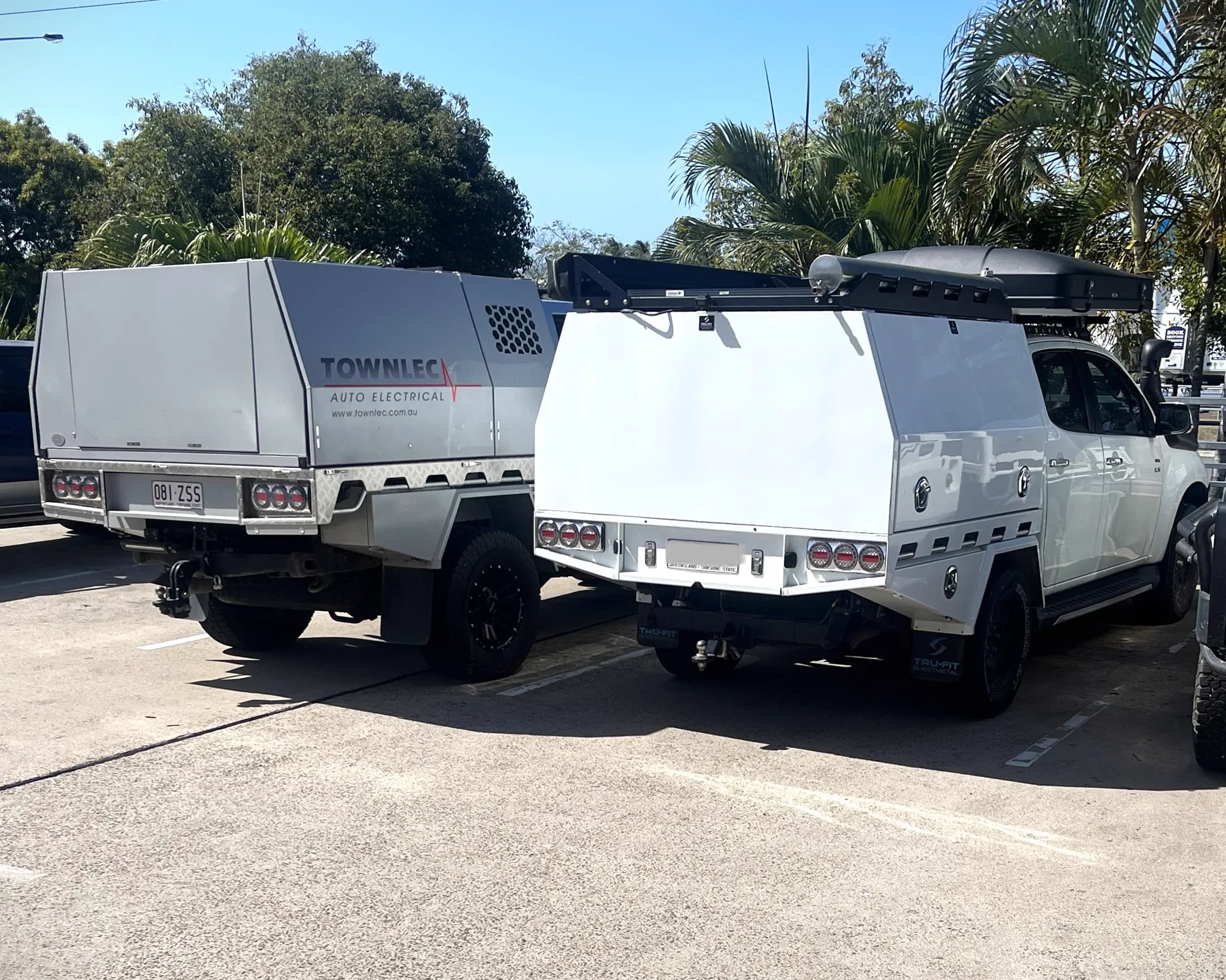 Two utes with alloy canopies parked side by side — the white canopy fitted with conventional T-handles, the Townlec canopy beside it running LokaBox with no external hardware at all
