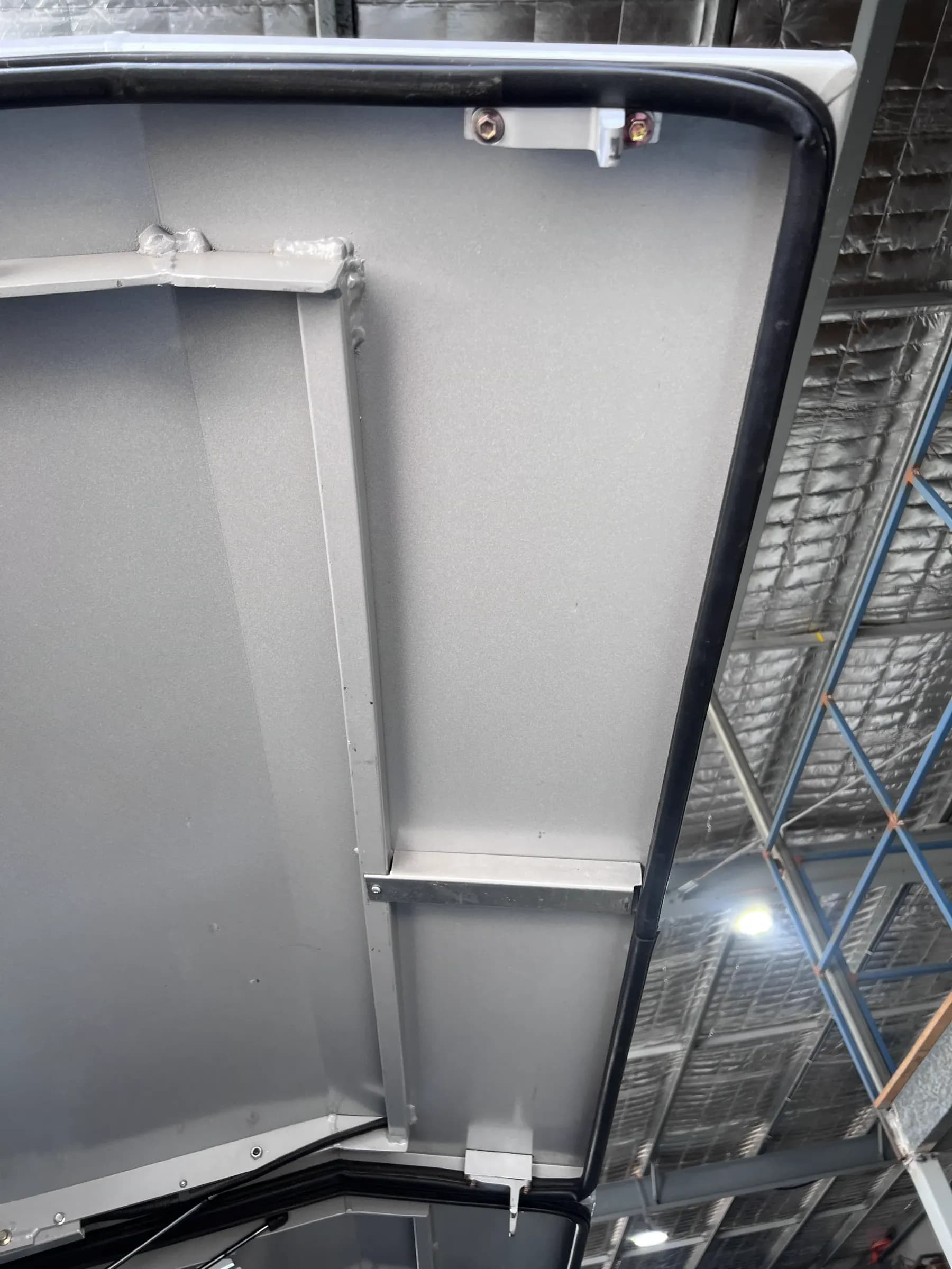 Canopy door standing open showing the LokaBox latch mounted in the door frame with its cabling run along the edge