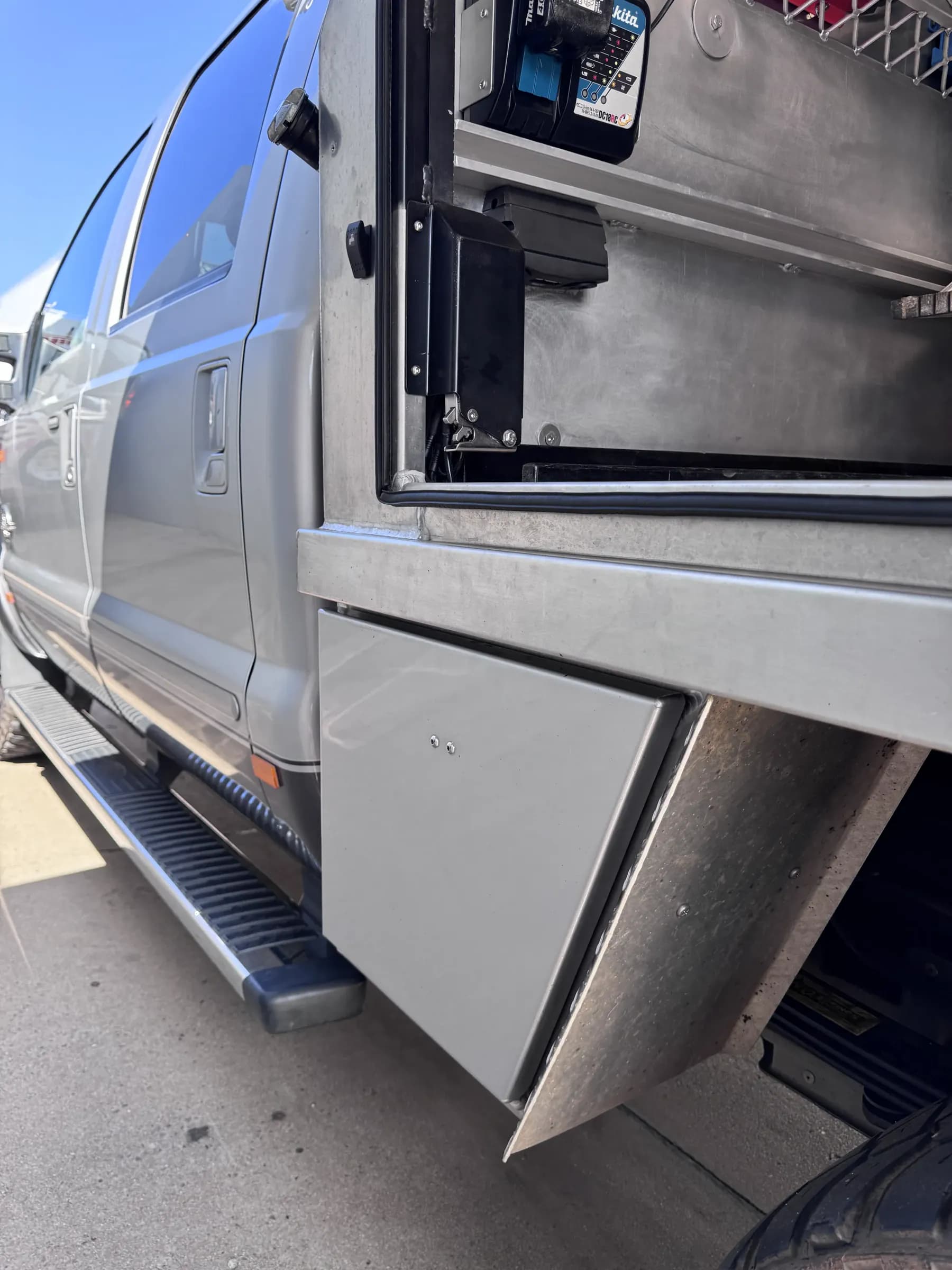 Toolbox door on a service body standing open with the LokaBox latch fitted where the original hardware was