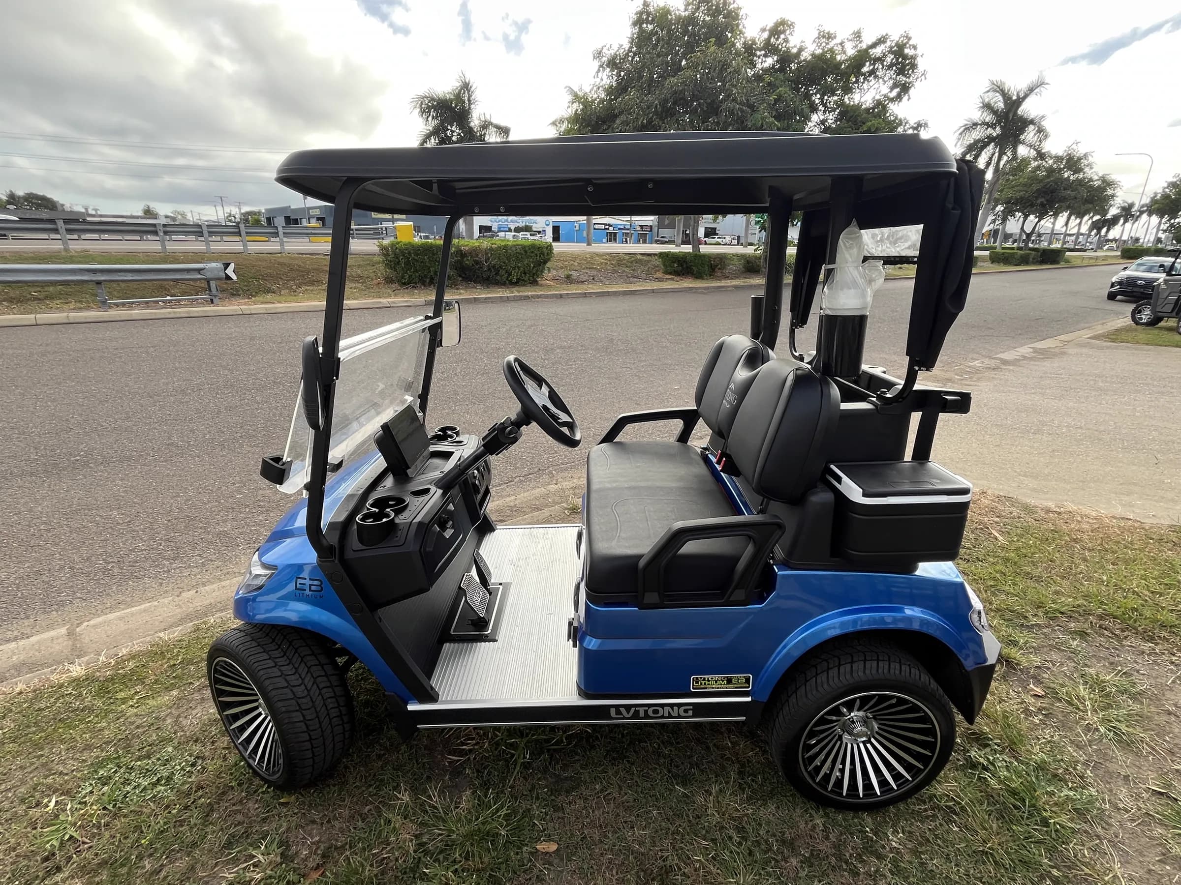 A blue LVTong four-seater golf cart with Eco Battery lithium badging parked outside the Townlec workshop in Townsville